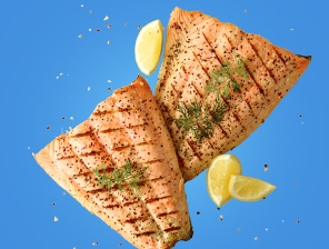 Grilled salmon with seasoning and lemons.