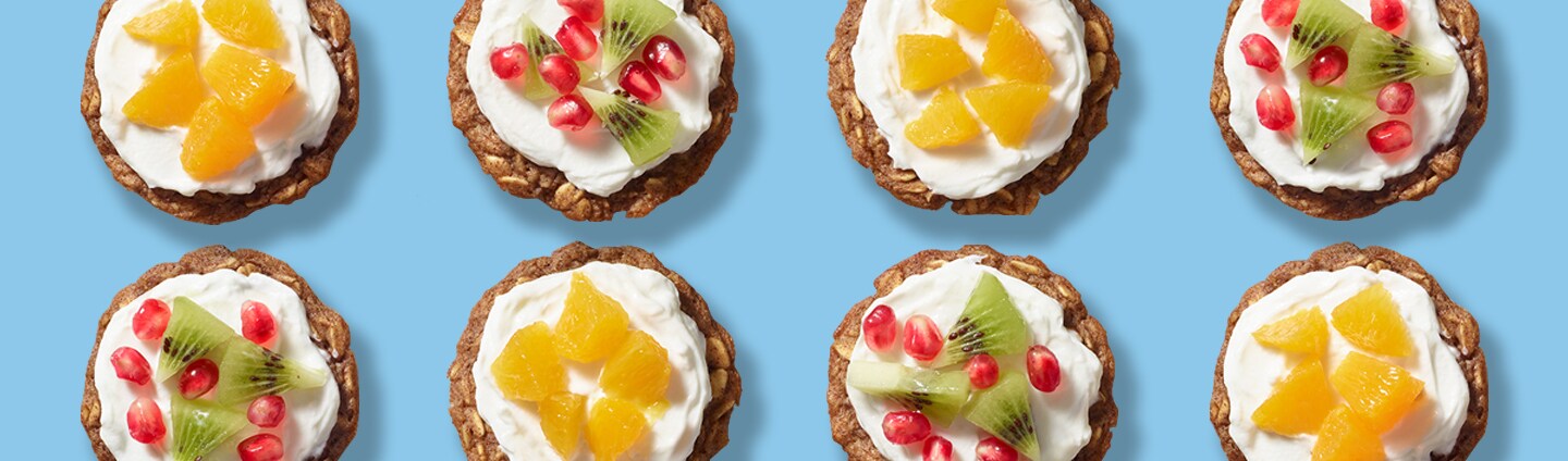 Assorted baked oatmeal cups topped with yogurt, oranges, kiwi and pomegranates