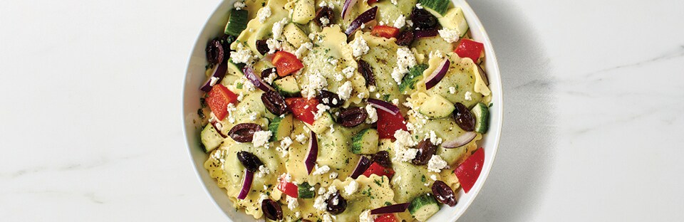 Ravioli with fresh tomatoes, mozzarella, and basil, drizzled with balsamic glaze